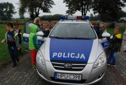 policjanci podczas pogadanki z dziećmi na temat bezpieczeństwa na drodze - pokaz radiowozu