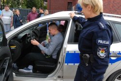 policjanci podczas pogadanki z dziećmi na temat bezpieczeństwa na drodze - pokaz radiowozu