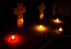 pomniki na cmentarzu i świecące się znicze