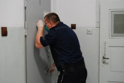 kontrola przez policjanta zatrzymanych w celi włąmywaczy