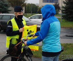 policjanci rozdają kamizelki odblaskowe pieszym i rowerzystą