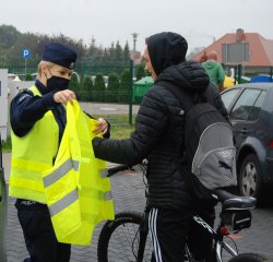 policjanci rozdają kamizelki odblaskowe pieszym i rowerzystą 1