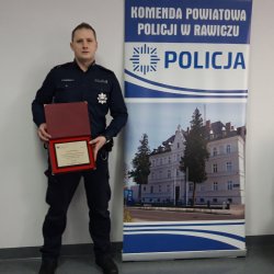 policjant asp. Karol Wieczorek z wyróżnieniem w ręku