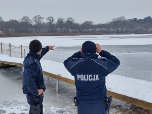 policjanci obserwujący zbiorniki wodne